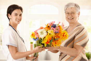 caregiver and patient holding flowers